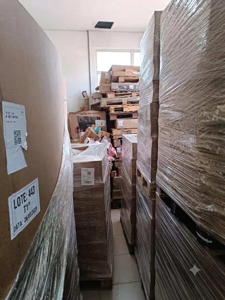 Corredor entre pallets fechados com filme stretch, com etiqueta de lote visível