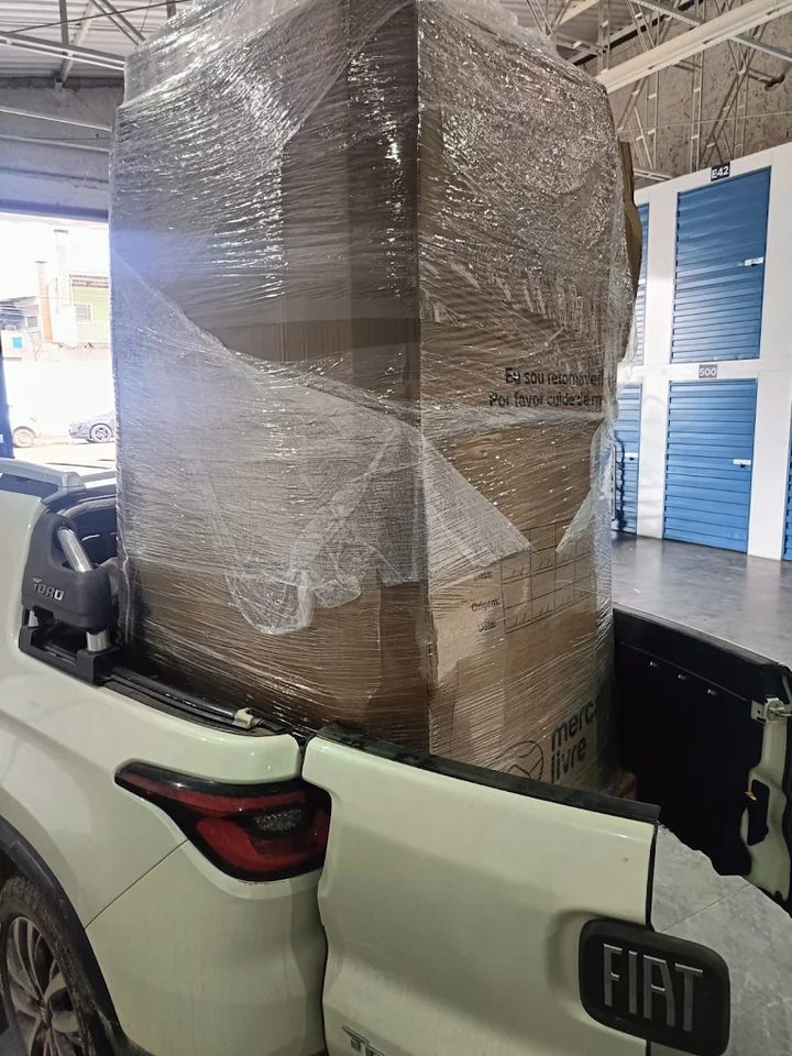 Pallet fechado com filme stretch carregado na caçamba de uma picape no depósito
